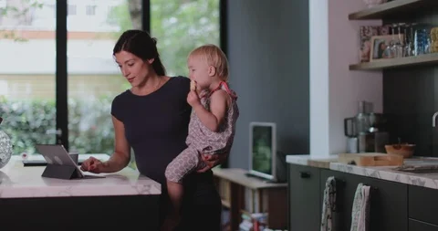 Pregnant mother with child working from home Stock Footage