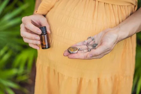 Pregnant woman after 40 demonstrating the use of an aroma pendant, combining Stock Photos