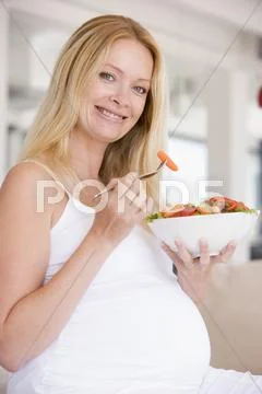 Pregnant woman with bowl of salad smiling Stock Photos