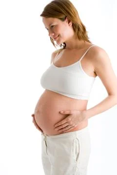 Pregnant woman holding exposed belly smiling Stock Photos