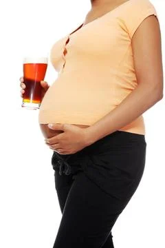 Pregnant woman holding a glass of alcohol next to her tummy Pregnant woman... Stock Photos