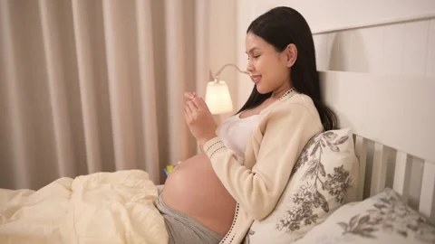 Pregnant woman holding positive pregnancy test