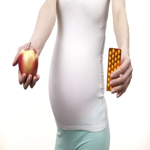 Pregnant woman holds apple fruit and pills 4K Stock Footage