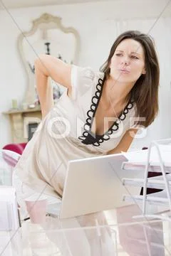 Pregnant woman in home office with a sore back Stock-Fotos