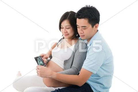 Pregnant woman with husband holding ultrasound scan of unborn child Stock-Fotos