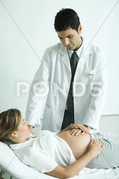 Pregnant Woman Lying On Back, Doctor's Hand On Stomach