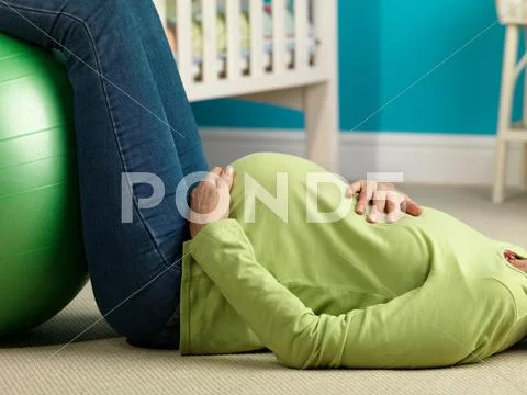 Pregnant Woman Lying On Floor Exercising