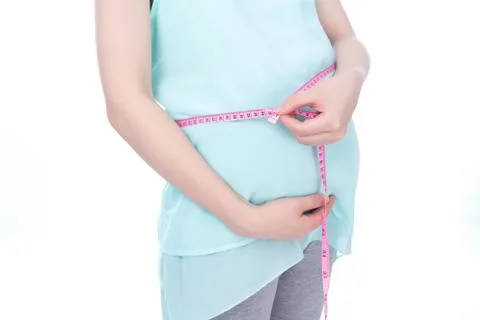 Pregnant woman measures her tummy by tape measure Stock Photos