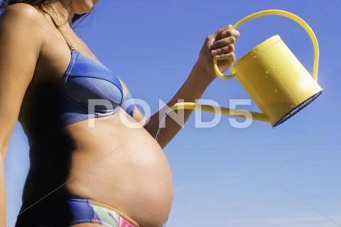 Pregnant woman, pouring belly, midsection, side view Stock Photos
