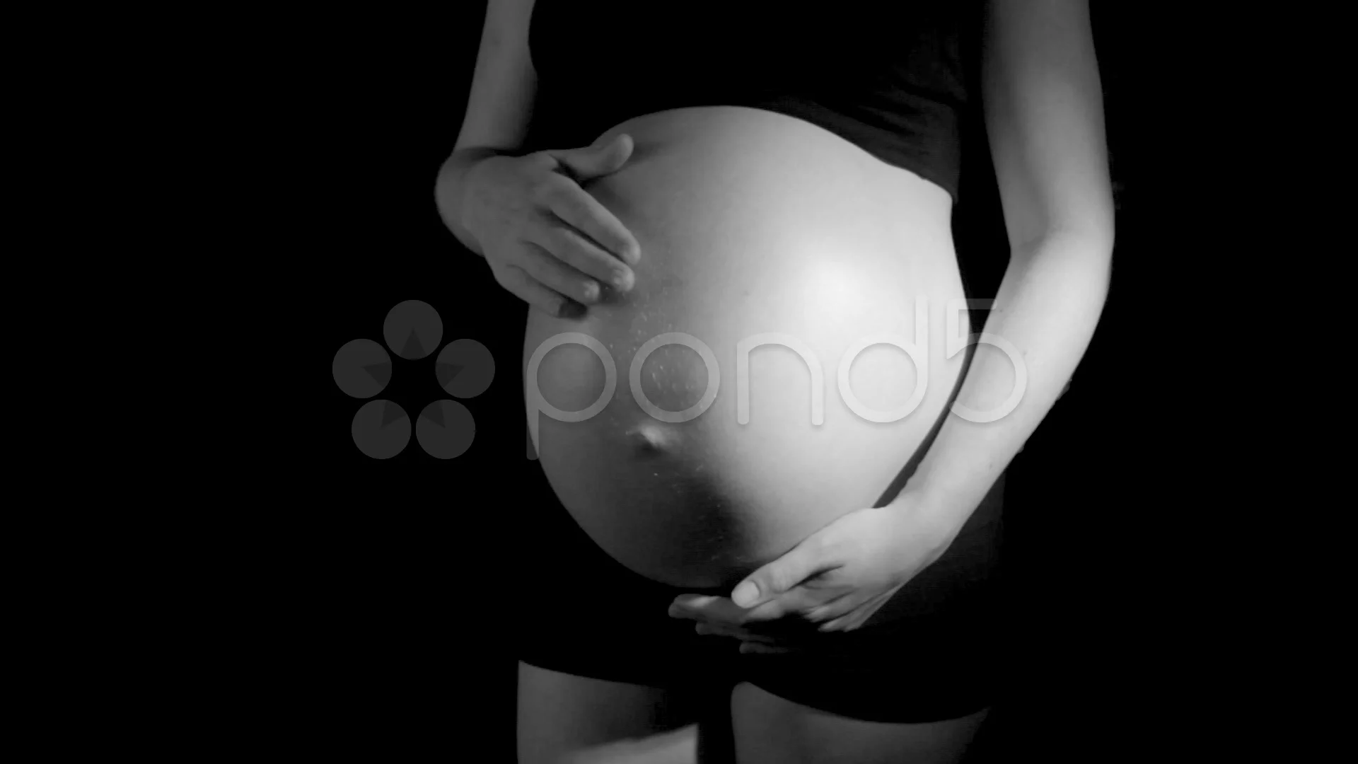 pregnant woman rubs belly in black and white (HD)