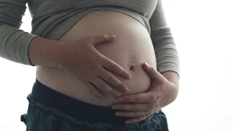 Pregnant woman touching and rubbing her belly Stock Footage