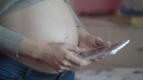 Pregnant Woman Using Tablet Computer And Touching Her Belly Stock Footage 56340007