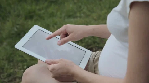 Pregnant woman using tablet pc in park Vídeo Stock 51834833
