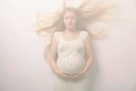 Pregnant woman with windblown hair Stock Photos