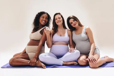 Pregnant women engaging in prenatal yoga for health and wellbeing Stock Photos