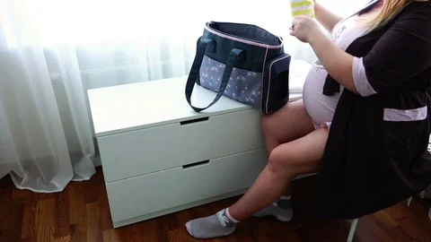 Pregnant young mother collects things in the maternity home getting ready Stock Footage
