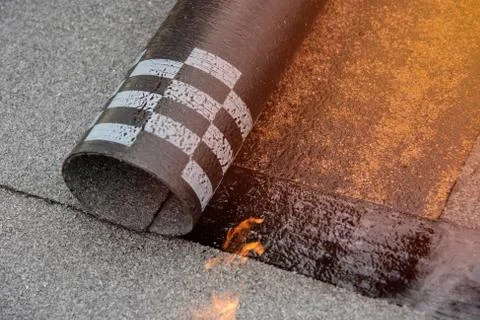 Preheating the edges of the roofing material. Stock Photos