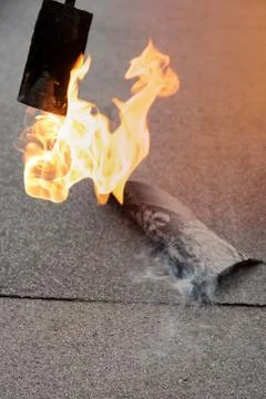 Preheating the edges of the roofing material. Stock Photos