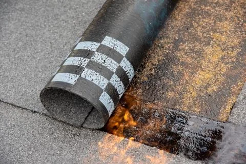 Preheating the edges of the roofing material. Stock Photos