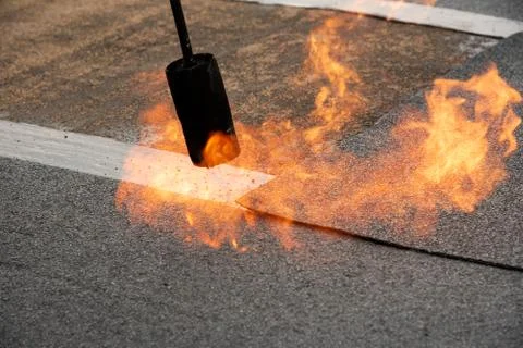 Preheating the edges of the roofing material. Stock Photos