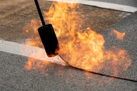 Preheating the edges of the roofing material. Stock Photos