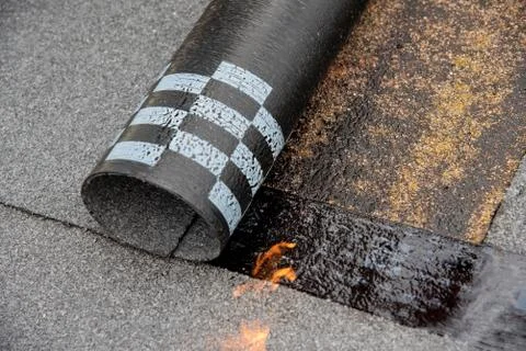 Preheating the edges of the roofing material. Stock Photos