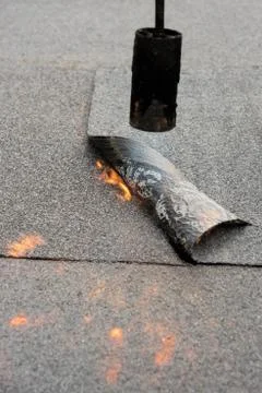 Preheating the edges of the roofing material. Stock Photos
