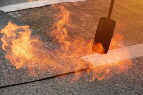 Preheating the edges of the roofing material. Stock Photos