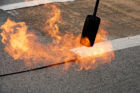 Preheating the edges of the roofing material. Stock Photos