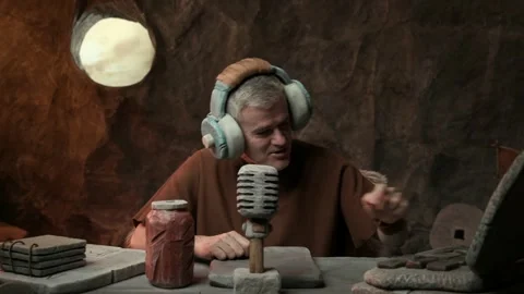 Prehistoric live streamer in the studio speaking into the microphone Stock Footage 333047070