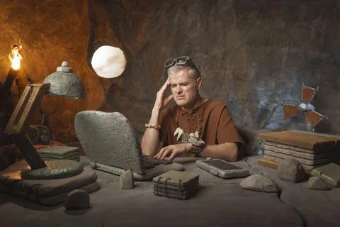 Prehistoric office worker having a bad headache Stock Photos