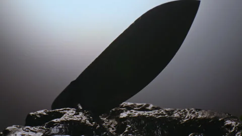 A premium exclusive kitchen knife in drops of water among the stones. It rotates Stock Footage 308526030