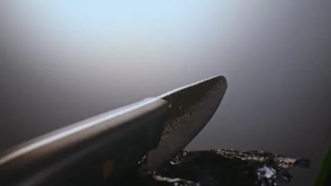 A premium exclusive kitchen knife in drops of water among the stones. It rotates Stock Footage 311681201