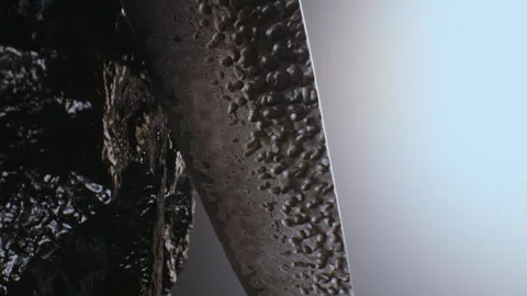 A premium exclusive kitchen knife in drops of water among the stones. It rotates Stock Footage 333549082