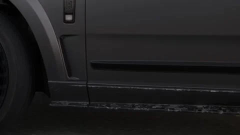 A premium expensive car rides on an asphalt road among the sand dunes of the Stock Footage 249148113