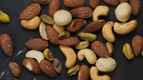 Premium healthy, roasted mixed nuts almonds, cashews, macadamias, and pistachios Stock Footage 320058342