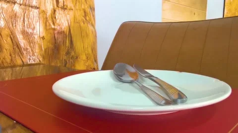 Premium restaurant table setup with empty plate fork knife spoon. Stock Footage 332323960