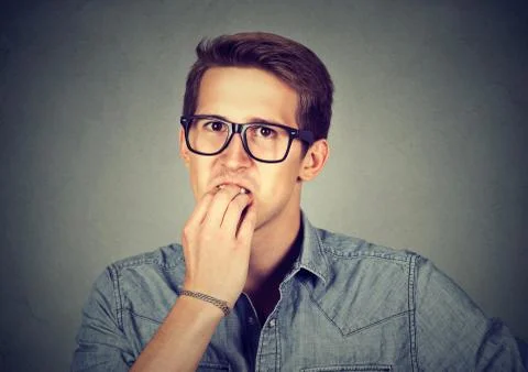 Preoccupied anxious man biting fingernails nervously Stock Photos
