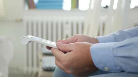 Preoccupied Man Sit on the Chair with Adding Machine in Hand Making Calculations Stock Footage 113632935