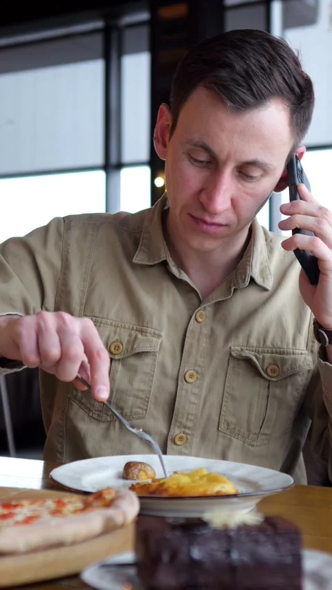 Preoccupied Man Talks On Smartphone During Meal, Exhibiting Classic Distracted 스톡 동영상 346989554