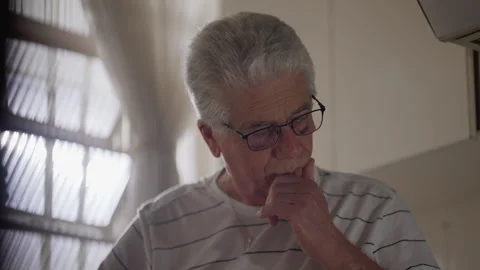Preoccupied senior man pondering solution to problem while standing at home.. Stock Footage 242163878