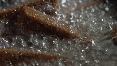 Preparation of beer snacks in deep fryer. Close-up of deep-fried bread rusks Stock Footage 94569758