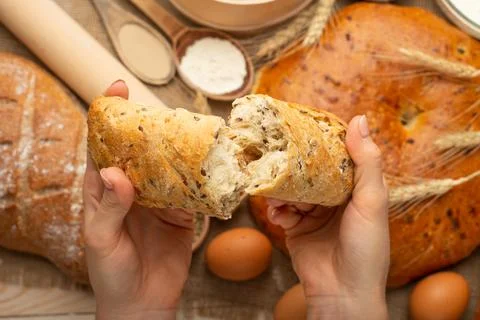 The preparation of bread, fresh bread in hands closeup on old wooden backgrou Stock Photos
