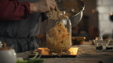 Preparation of cabbage for fermentation in a glass jar by a person in a kitc 스톡 동영상 331356361