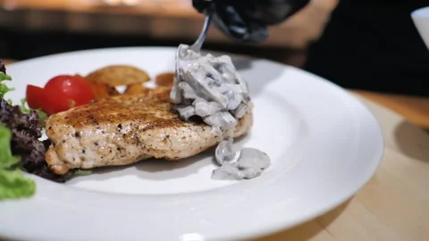 Preparation of chicken steak dishes for serving. mushrooms in cream sauce Stock Footage 205210245