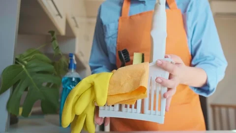 Preparation for cleaning work starts with gathering essentials, woman takes glov Stock Footage 301867937