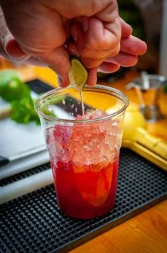 Preparation of cocktail. Adding ice, shaking ingredients and decorating with  Stock Photos