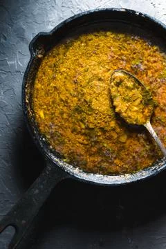 Preparation of curry paste in a cast-iron frying pan closeup. Indian food Stock Photos