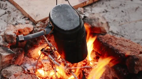Preparation of Dinner Cooks in a Small Pot Over an Open Fire Видео 64230980