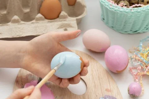 Preparation for Easter. The child is holding a large egg in his hands. Pastel Stock Photos